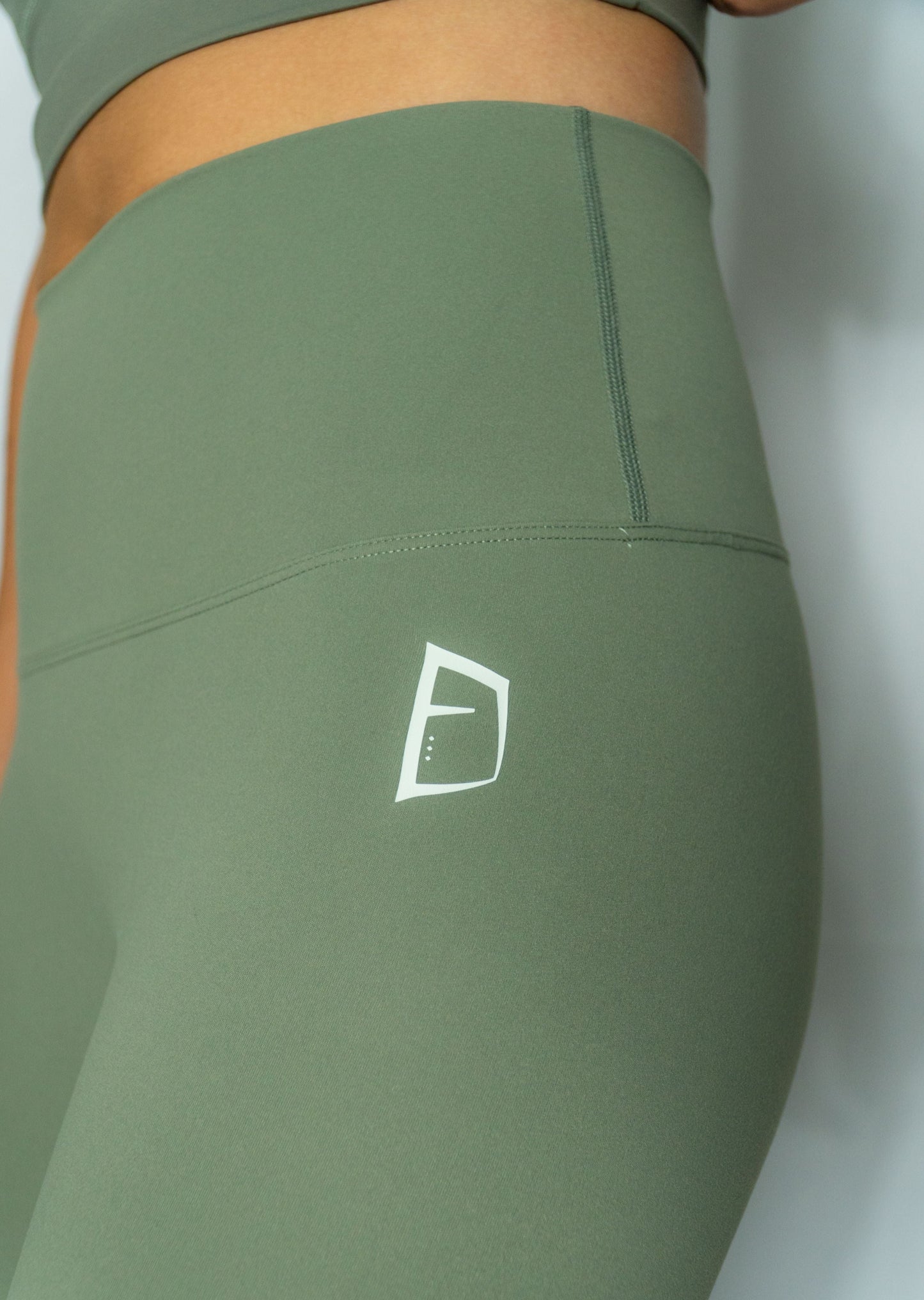 Leggings long Mecton de couleur vert sauge très confortable qui forme une deuxième peau. Matière Nylon pour le confort et elasthanne pour l'élasticité embrassant les formes Impression Mecton en vert clair hanche gauche et en bas du dos.