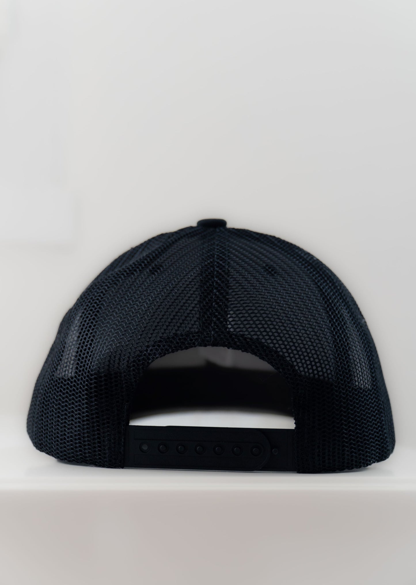 Casquette ajustable tucker noire type baseball brodée logo Mecton confortable, efficace pour se protéger du soleil avec maille respirante à l'arrière