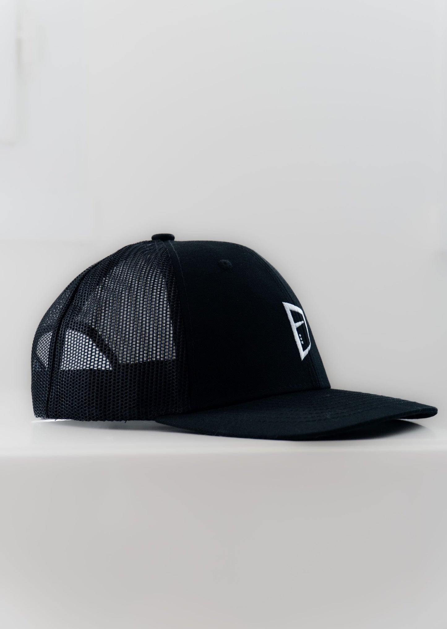 Casquette ajustable tucker noire type baseball brodée logo Mecton confortable, efficace pour se protéger du soleil avec maille respirante à l'arrière