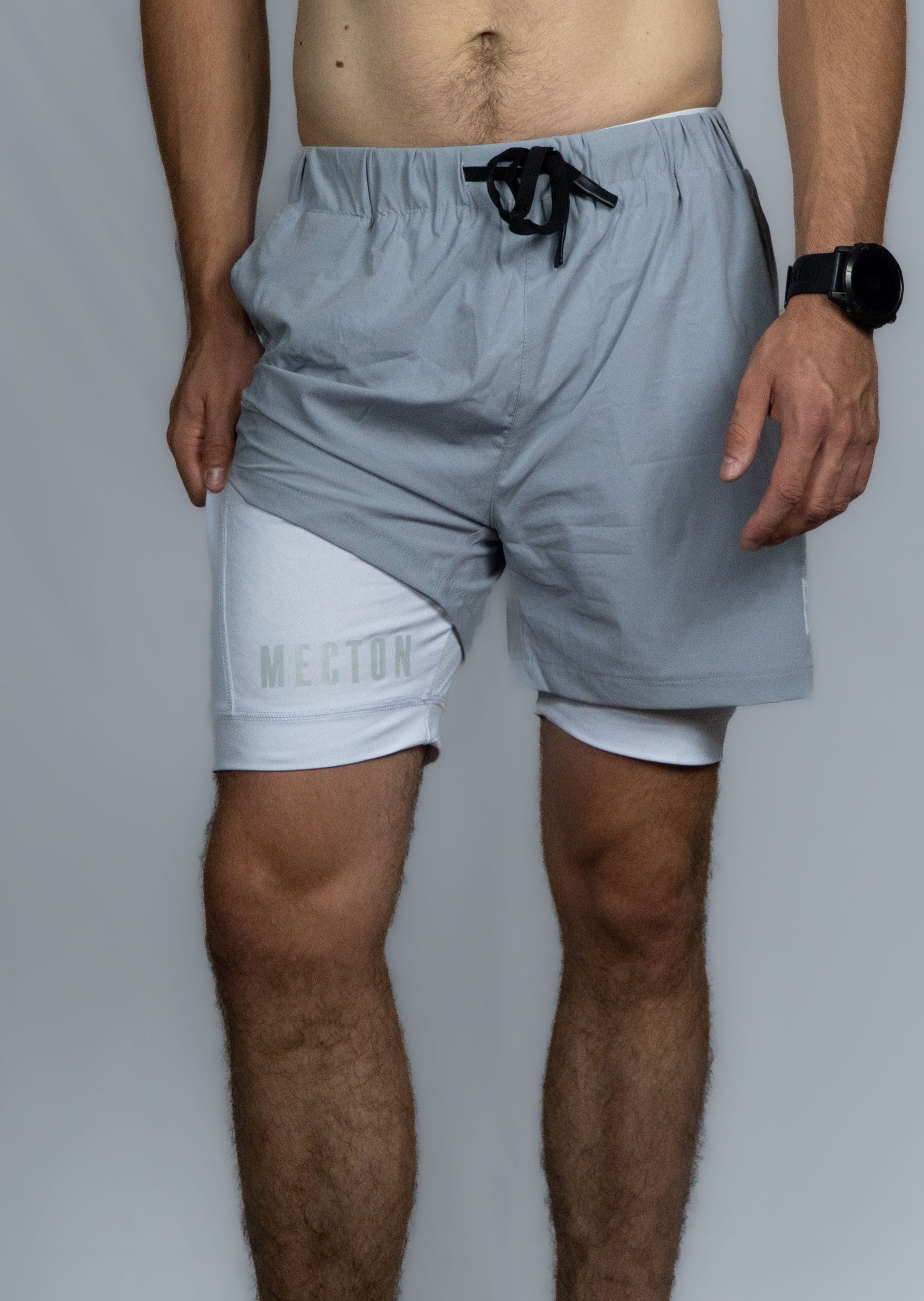 Short double couche Mecton disponible en deux coloris : blanc et gris ou noir. Short en nylon elasthanne pour garantir une elasticité et un confort optimal ainsi que son caleçon en polyester afin de profiter d'une légèreté. Il est conseillé de porter ce short sans sous vêtement pour apprécier le confort que propose ce short de qualité. Impression Mecton sur le short ainsi que le caleçon. Idéal pour le Crossfit, la course à pieds ou tout autre sport.